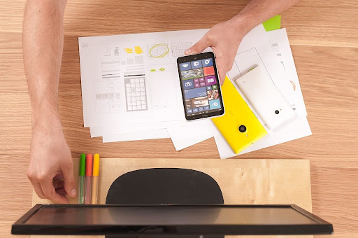 Vista superior de mesa com gráficos, planilhas e smartphone, representando o planejamento estratégico organizacional
