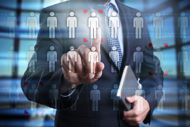 Executivo seleciona ícones de pessoas destacados em tela digital, representando gestão e retenção de talentos.
