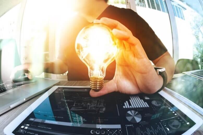 Uma mão segurando uma lâmpada acesa simbolizando as caracteristicas de um empreendedor