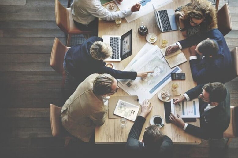 Equipe vista por cima trabalhando em plano de negócios em uma mesa