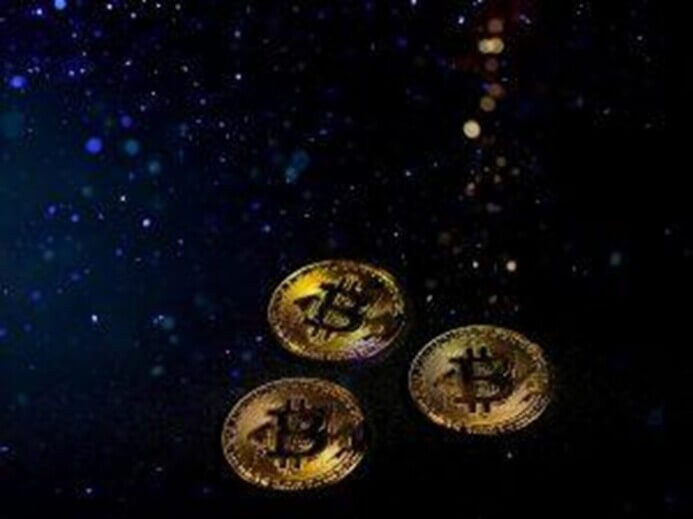 três moedas de bitcoin em um fundo preto
