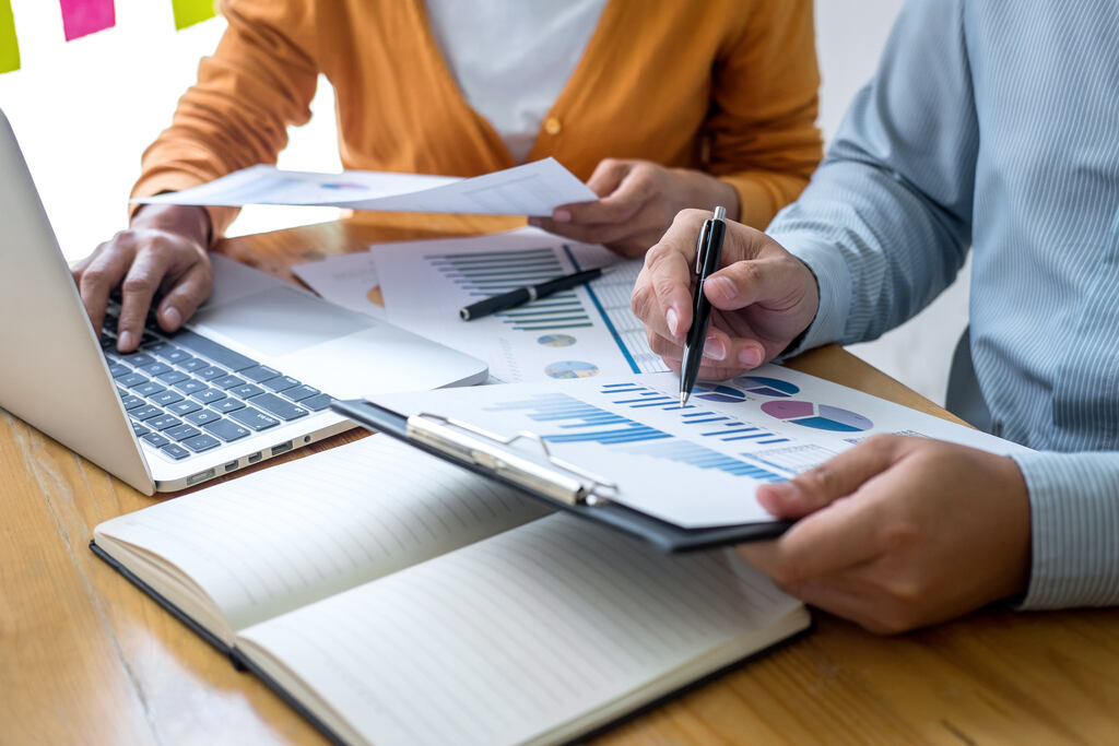 Equipe analisa gráficos e indicadores em reunião para planejar estratégias de geração de leads e crescimento digital.