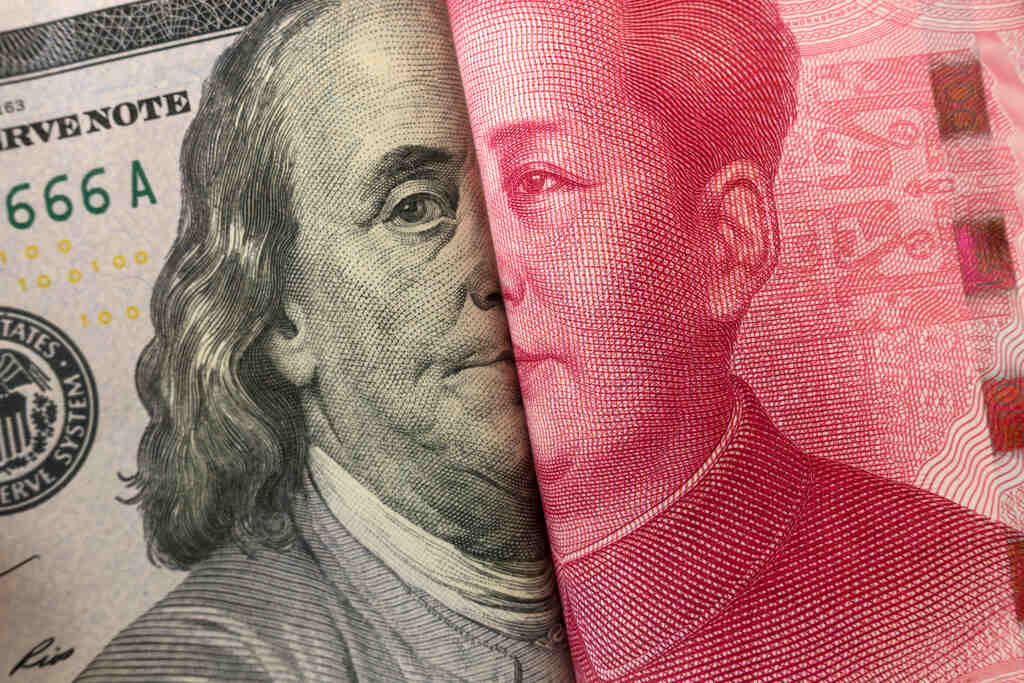 Notas de dólar e yuan representam os impactos da disputa econômica entre EUA e China sobre a economia global.