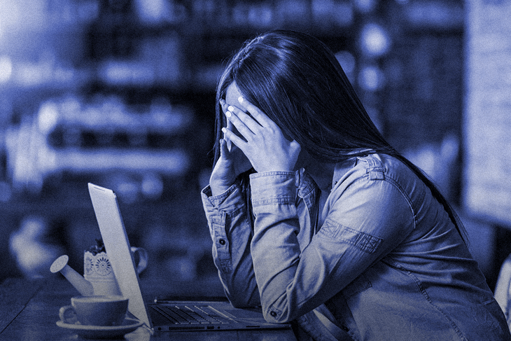 Mulher sofrendo cyberbullying na frente de um computador