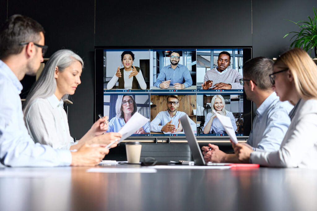 Colaboradores participam de videoconferência corporativa usando canais digitais para integração.