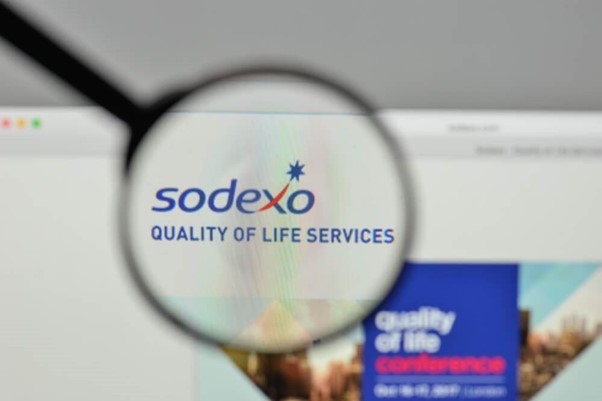 Lupa evidenciando o logo da Sodexo como exemplo de sucessos em diversidade e inclusão nas empresas