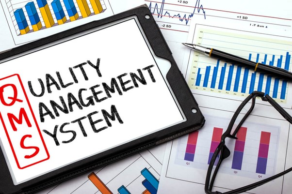 tablet escrito "Quality management system" com as iniciais "QMS" em evidência