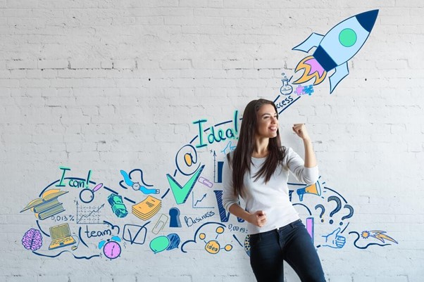 Mulher empreendedora motivada com ilustrações pintadas na parede atrás