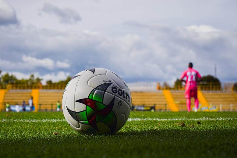 Bola de futebol em campo demonstrando a participação do brasil na copa do mundo