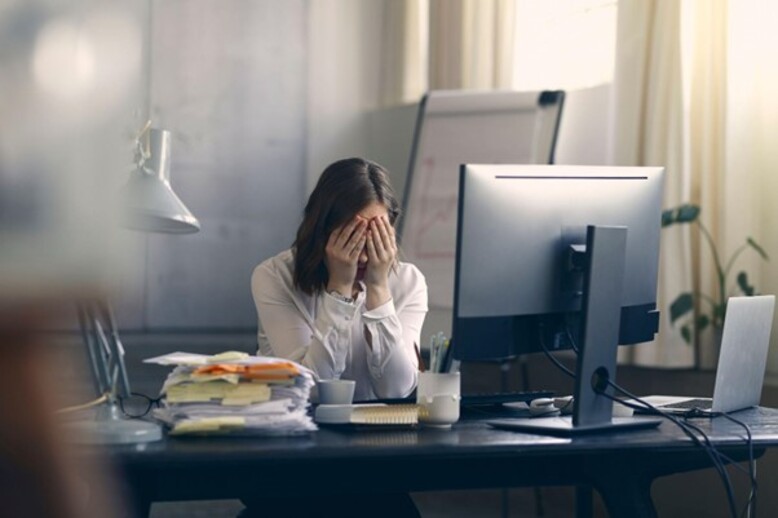Mulher em situação de estresse no ambiente de trabalho adota postura de quiet quitting