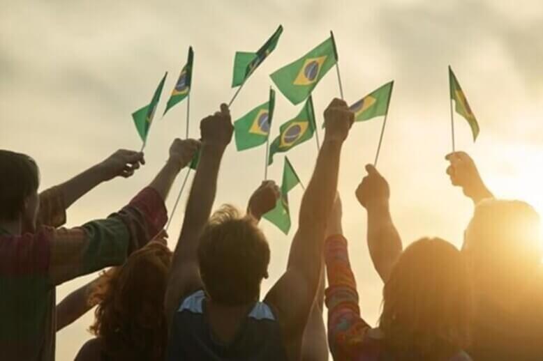 Cidadãos brasileiros erguendo a bandeira do Brasil