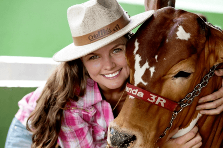 Adriane, um exemplo de mulheres do agro, abraçando um cavalo de corrida