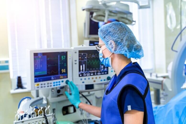 Enfermeira operando um monitor hospitalar, tecnologia espacial desenvolvida para monitorar a saúde dos astronautas