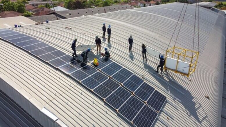 Painéis solares sendo aplicados no teto de uma fábrica, a fim de aproveitar melhor a captação da energia solar