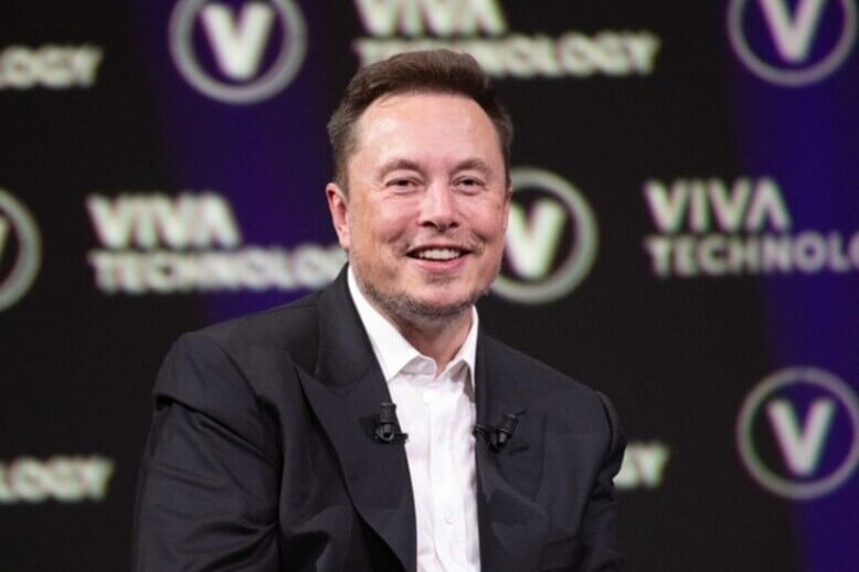 Elon Musk sentado em uma entrevista coletiva