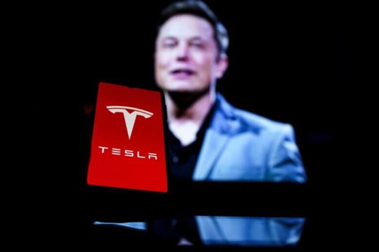 Elon Musk em pé conduzindo apresentação da Tesla