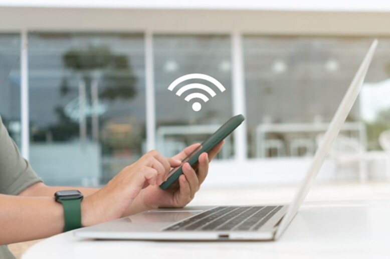 Colaborador conectando-se a internet no celular e notebook através do wifi 7