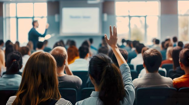 Equipe de funcionários participando de uma sessão de palestra em um ambiente de educação corporativa.