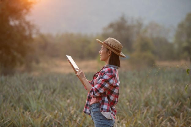 Produtora rural utilizando tecnologia no campo para melhorar a gestão agrícola e aumentar a produtividade.