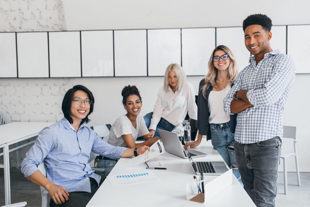 Equipe diversa em escritório colaborativo, representando práticas de responsabilidade social corporativa e inclusão no trabalho.