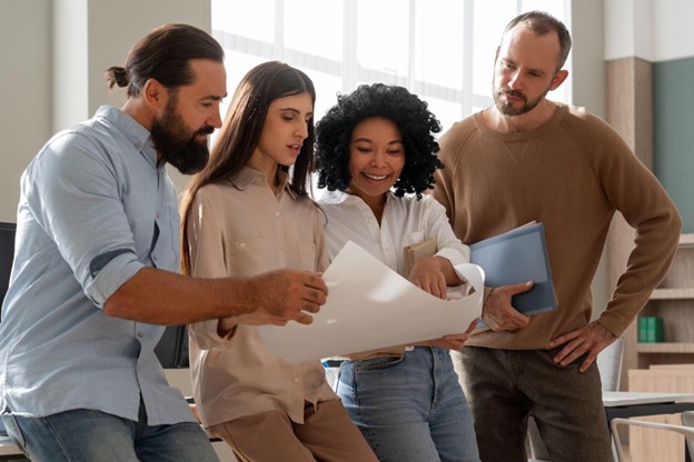 Profissionais discutem projeto em ambiente colaborativo, destacando a importância da flexibilidade no trabalho moderno.