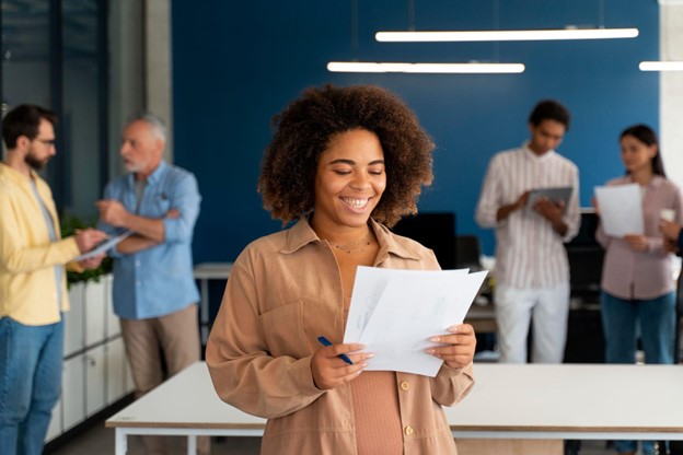 Profissional sorridente analisando documentos em um ambiente corporativo colaborativo, representando o futuro do trabalho 2025.