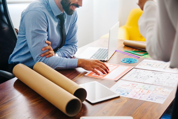 Profissionais discutem planejamento em um ambiente colaborativo, aplicando aprendizagem baseada em projetos para soluções inovadoras.