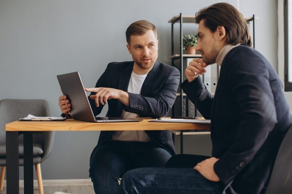 Consultor discute plano de sucessão empresarial com cliente, analisando estratégias e tomada de decisões.