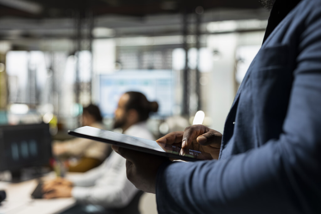 Gestor acompanha indicadores em tablet para monitorar atividades e otimizar processos internos.