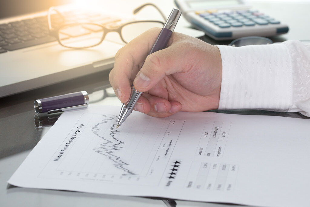 Profissional analisa gráfico financeiro para avaliar custos, receitas e desempenho empresarial.