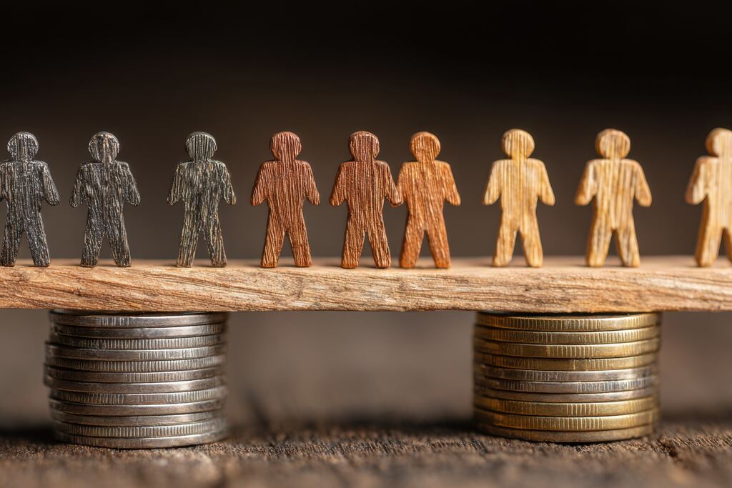 Sistema econômico representado por figuras sobre moedas em equilíbrio, ilustrando distribuição de renda e organização da economia.