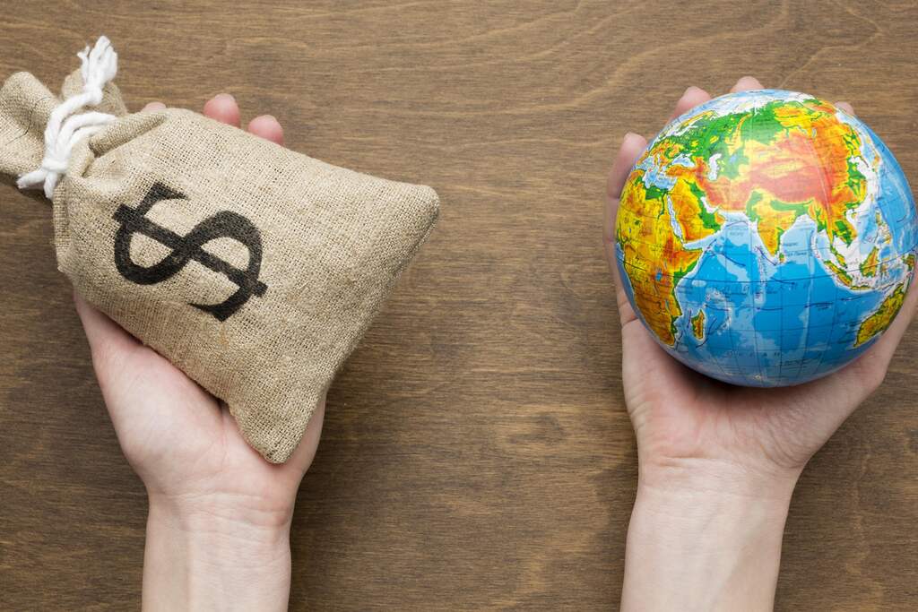 Mãos segurando saco de dinheiro e globo terrestre, simbolizando economia mista, mercado e atuação do Estado.