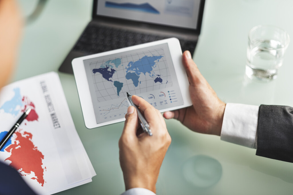 Profissional avalia indicadores econômicos e mercados internacionais para atuação em comércio exterior.