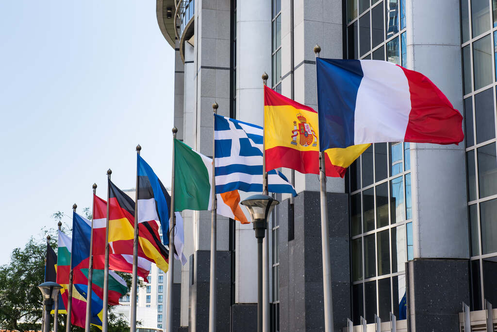 Bandeiras de diversos países em frente a edifício oficial ilustram o que é multilateralismo nas relações internacionais.
