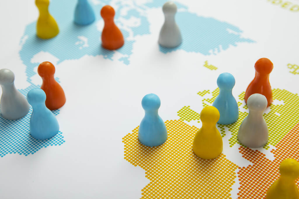 Peões sobre mapa-múndi representam hard power e soft power nas estratégias de influência entre países.
