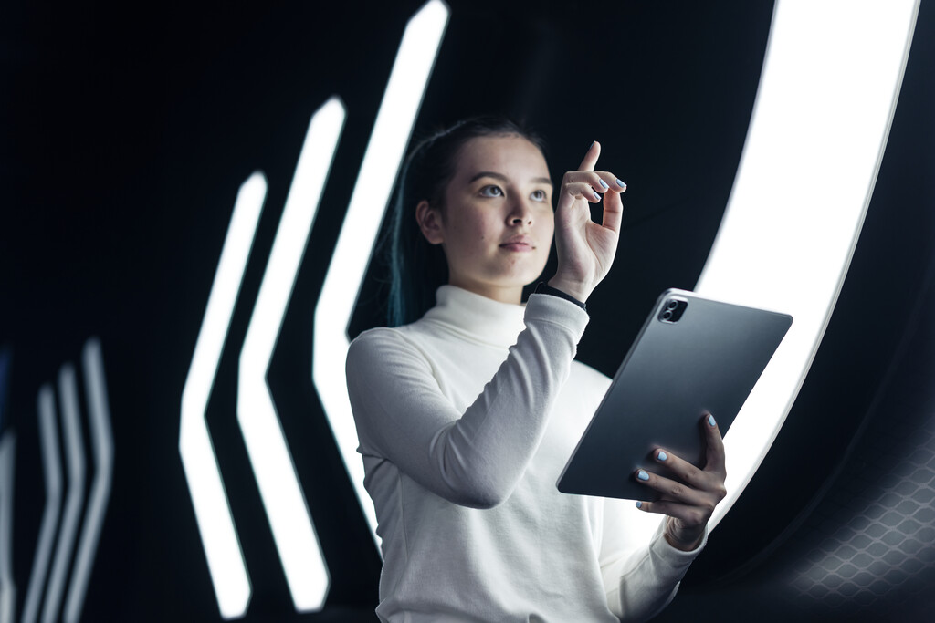 Profissional utiliza tablet em ambiente tecnológico, representando adaptação às competências do mercado digital.