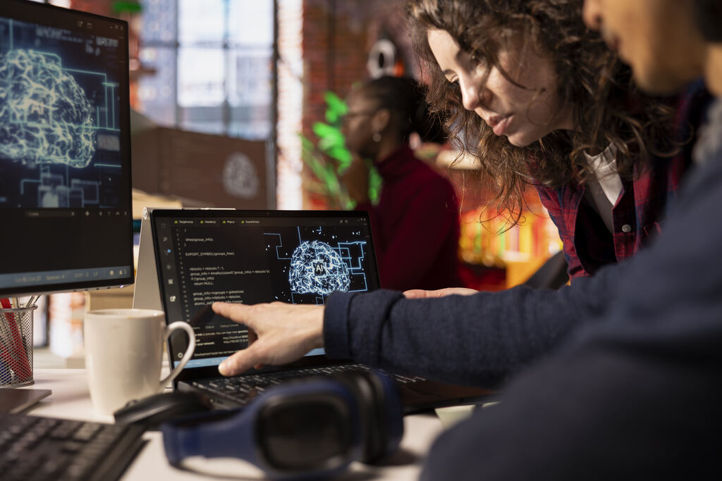Profissionais analisam dados e inteligência artificial em computador, destacando competências digitais e inovação.
