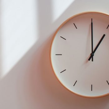 Relógio de parede branco marcando horas, simbolizando organização e gestão do tempo.